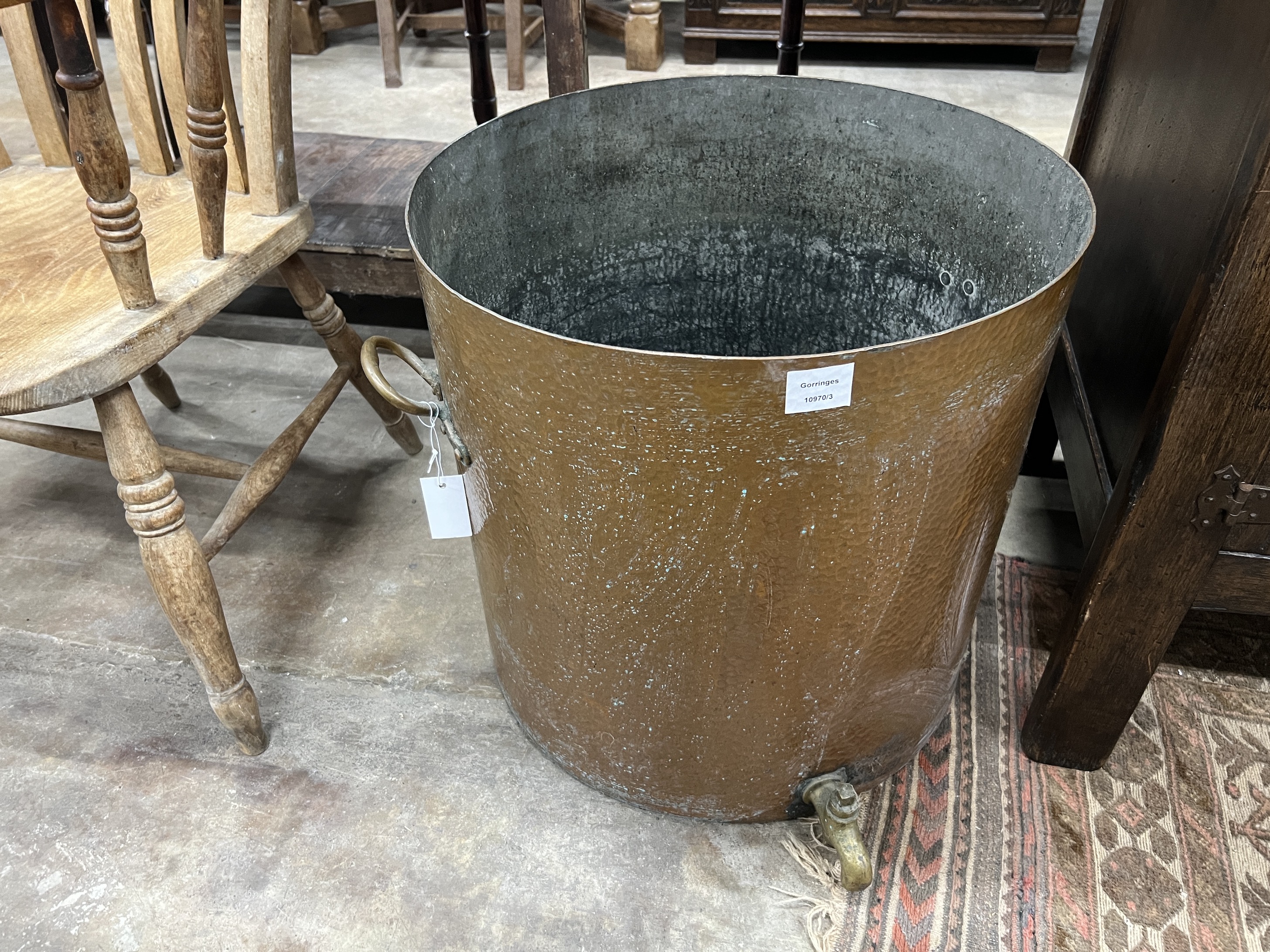 A large Victorian circular hammered copper cauldron with brass spigot, diameter 52cm, height 52cm